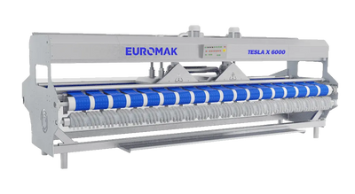 rug finishing machine applying final grooming touches - Industrial carpet and rug finishing machine with blue brushes and a gray body, labeled 'EUROMAK TESLA X 6000'.